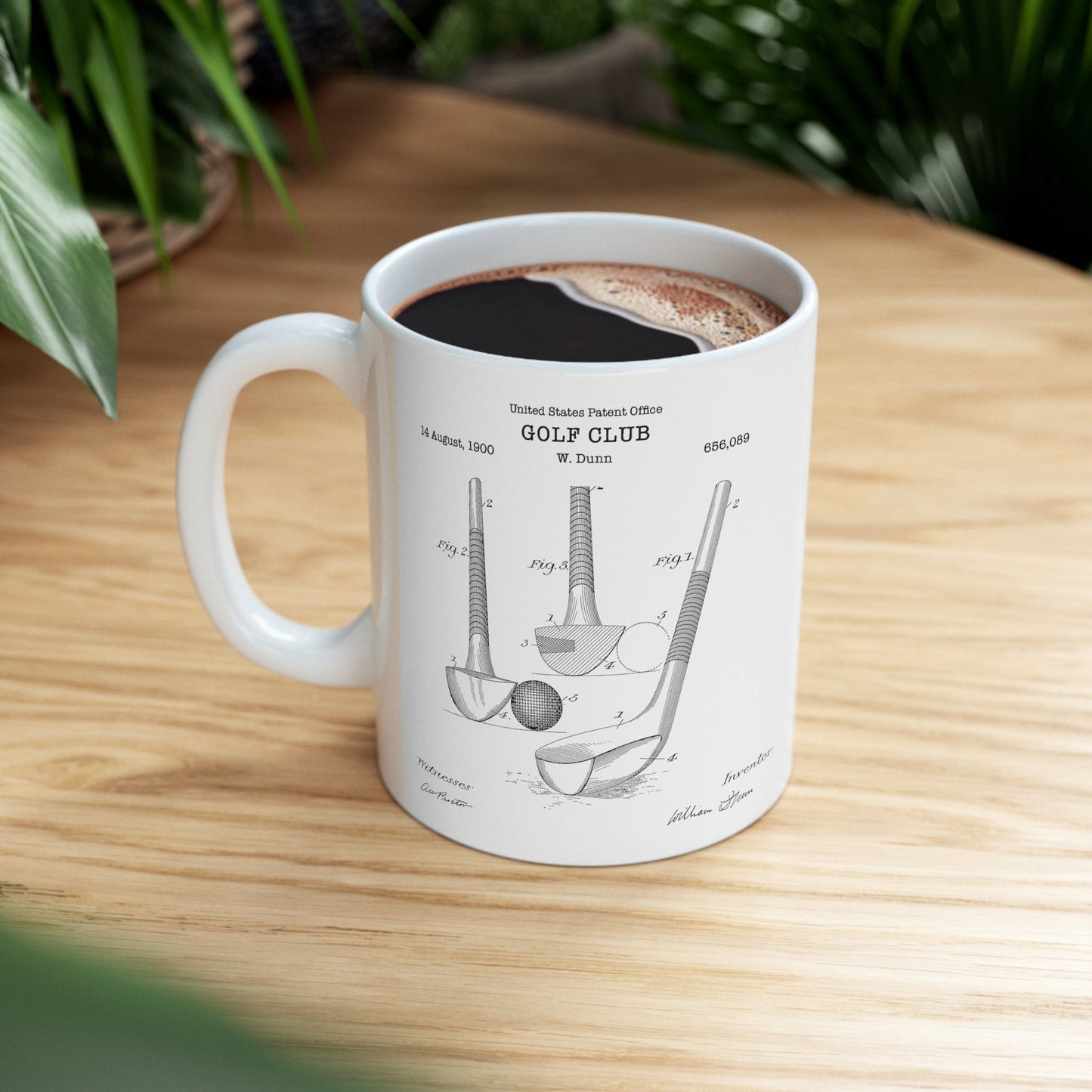 a cup of coffee with a drawing of a golf club on it