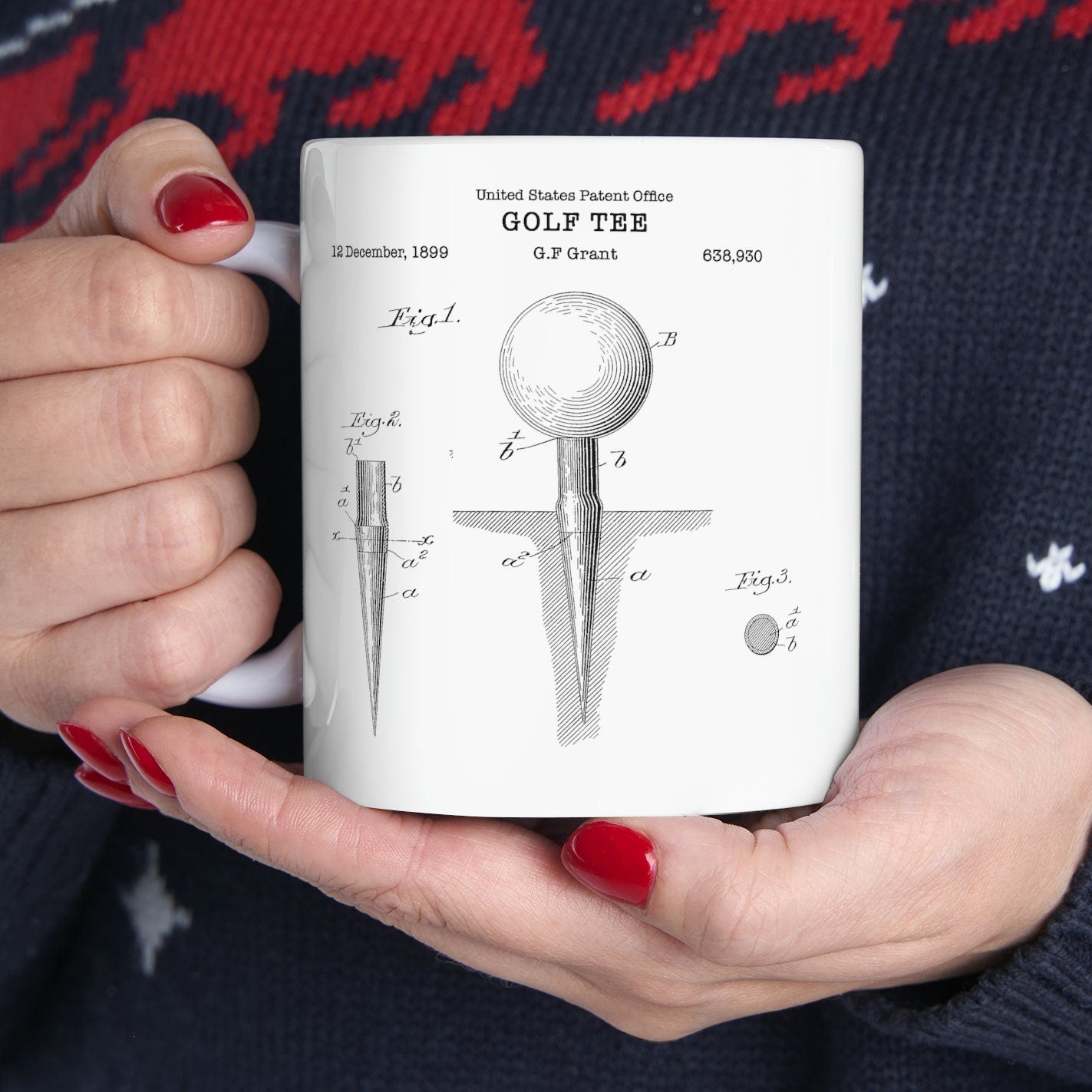 a coffee mug with a golf ball and tees on it