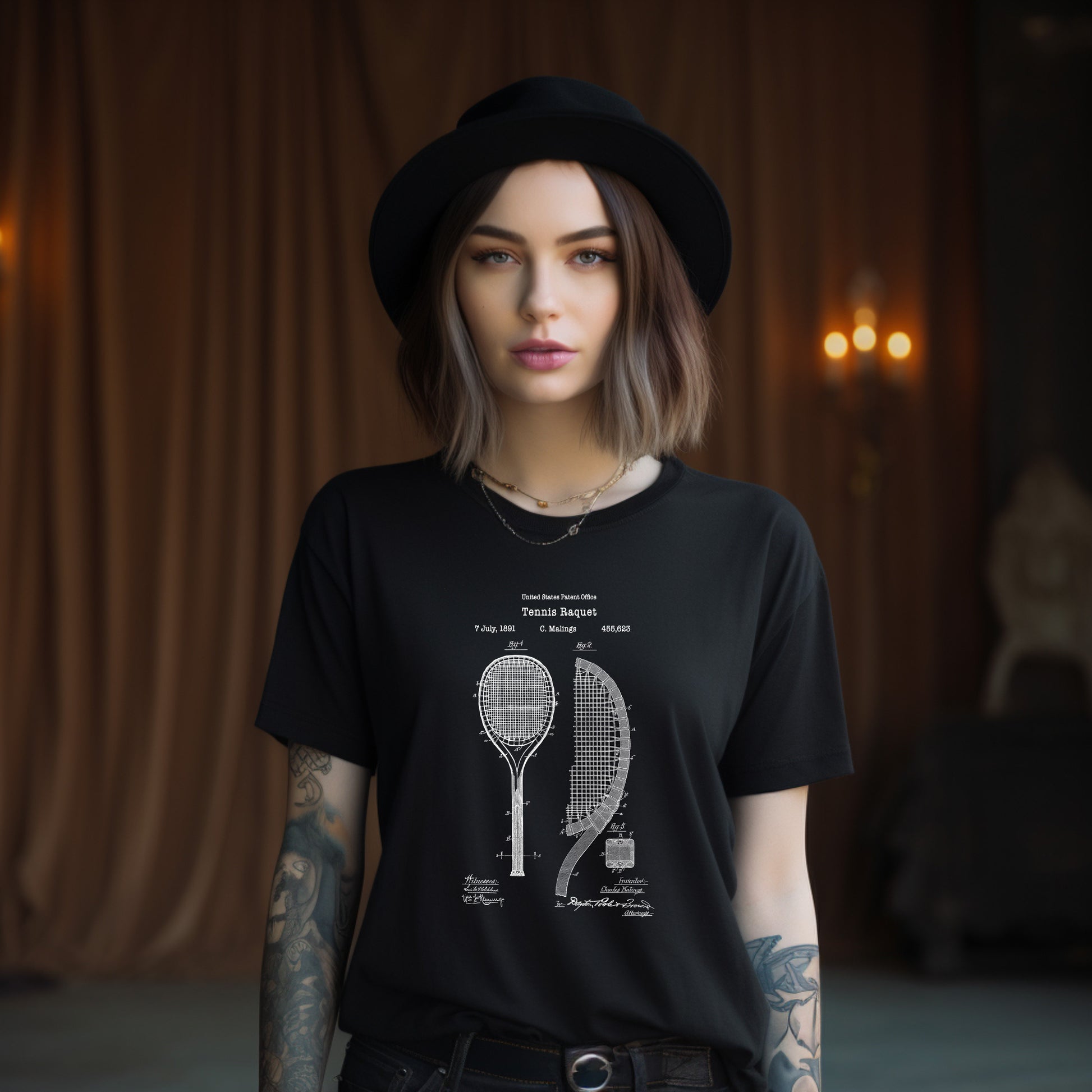 a woman wearing a black t - shirt with a drawing of a tennis racket